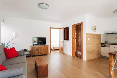 a living room with a couch and a kitchen at Apartment House Blazar in Tolmin