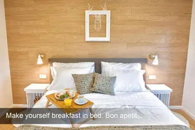 a bed with a tray of food on it at 4* Green Heaven in centre of Bled in Bled