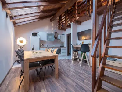 a kitchen and dining room with a wooden table and chairs at Vila Bovec Sky mansard apartment in Bovec