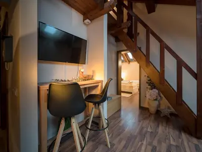 a room with a desk and a television and a chair at Vila Bovec Sky mansard apartment in Bovec