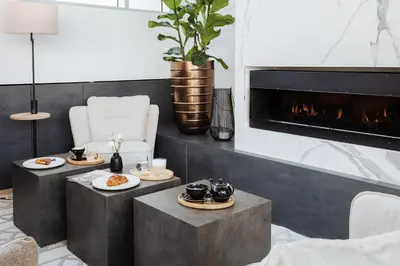 a living room with two tables and a fireplace at Hotel Slatina Superior in Rogaška Slatina