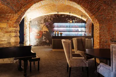 a room with a bar with a piano and chairs at Hotel Slatina Superior in Rogaška Slatina