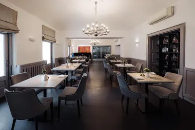 a restaurant with tables and chairs and a chandelier at Hotel Slatina Superior in Rogaška Slatina