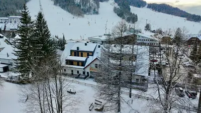 a town in the snow with buildings and trees at Vila Mojca SKI IN&OUT - Apartmaji Lena in Kranjska Gora