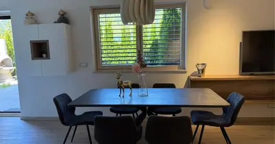 a dining room with a table and chairs and a tv at Vila Mojca SKI IN&OUT - Apartmaji Lena in Kranjska Gora