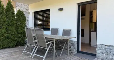 a wooden table and four chairs on a patio at Vila Mojca SKI IN&OUT - Apartmaji Lena in Kranjska Gora