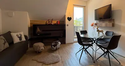 a living room with a table and a piano at Vila Mojca SKI IN&OUT - Apartmaji Lena in Kranjska Gora