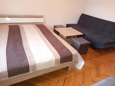 a bedroom with a bed and a couch at Apartment Carmen in Brezje