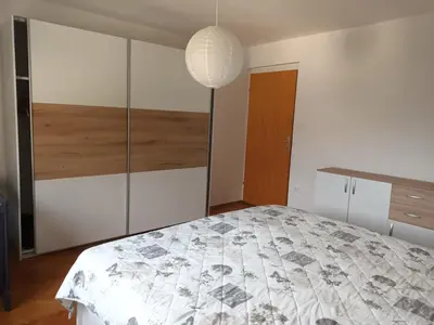 a bedroom with a bed and a pendant light at Apartment Carmen in Brezje