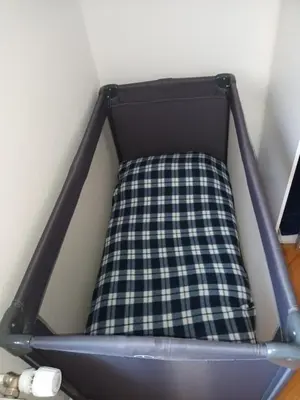a bed with a plaid sheet in a room at Apartment Carmen in Brezje