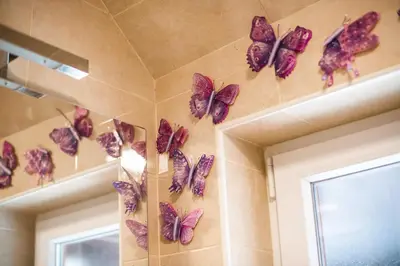 a bunch of purple butterflies hanging on a wall at Apartment Carmen in Brezje
