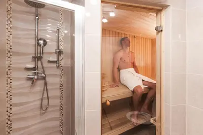 a man sitting in a sauna in a shower at Čarman House in Bled