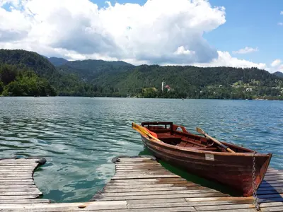 a wooden boat sitting at a dock on a lake at Čarman House in Bled