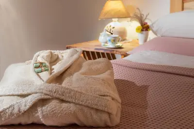 a blanket on a bed next to a table at Bio Apartments Trnulja in Ljubljana