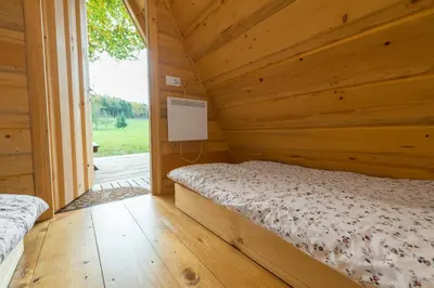 a log cabin bedroom with a bed and a window at Glamping Village - Speleo Camp in Logatec