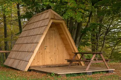 a wooden doghouse with a table in front of it at Glamping Village - Speleo Camp in Logatec