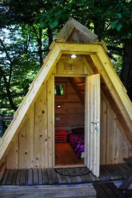 a wooden cabin with a bed inside of it at Glamping Village - Speleo Camp in Logatec