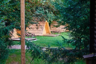 a backyard with two picnic tables and a tent at Glamping Village - Speleo Camp in Logatec