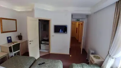 a room with a bed and a tv on a wall at Guest House Šterk in Nova Gorica