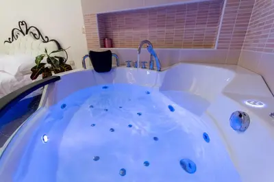 a white tub with a faucet in a bathroom at Guest House Šterk in Nova Gorica