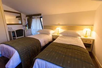 a hotel room with two beds and two lamps at Guest House Šterk in Nova Gorica
