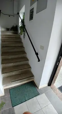 a staircase in a house with a green rug at Guest House Šterk in Nova Gorica