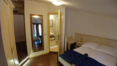 a bedroom with a large bed and a mirror at Guest House Šterk in Nova Gorica