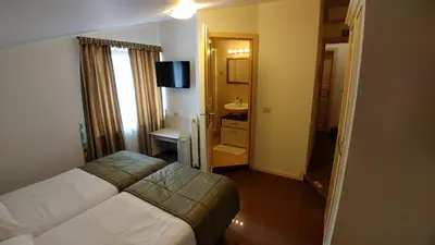 a hotel room with a bed and a bathroom at Guest House Šterk in Nova Gorica
