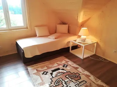 a bedroom with a bed with a lamp and a rug at Holiday Home- Mountain Lodge Gorjuše Pokljuka Bohinj in Koprivnik v Bohinju