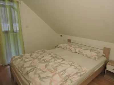 a small bed in a room with a window at Apartments Gubanec in Cerklje na Gorenjskem