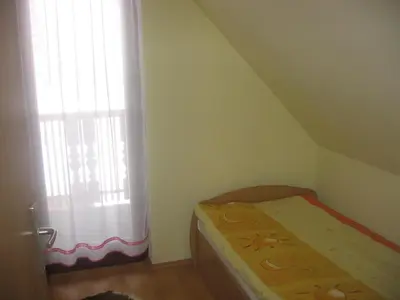 a small bedroom with a bed and a window at Apartments Gubanec in Cerklje na Gorenjskem