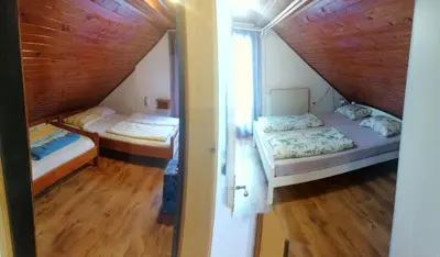 two beds in a room with a attic at Apartments Gubanec in Cerklje na Gorenjskem