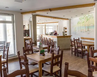 a restaurant with wooden tables and chairs and a bar at Houston Resort in Radovljica