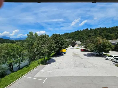 a parking lot next to a river with trees at Houston Resort in Radovljica