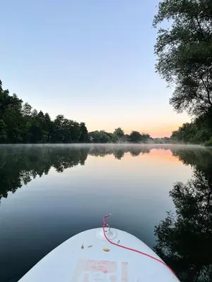 a boat on a lake with fog on the water at Vintage tent at the Lovsin Estate in Metlika