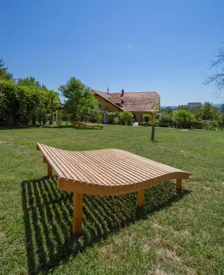 a wooden bench sitting in the middle of a field at Panorama B&B in Ptuj