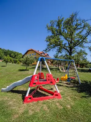 a playground with a swing set in a field at Panorama B&B in Ptuj