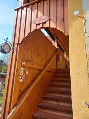 a staircase leading up to a building with a wooden wall at Tomas Old House - River Apartments in Visoko