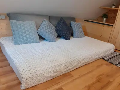 a bed with blue and white pillows on it at Tomas Old House - River Apartments in Visoko