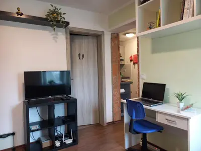 a room with a desk with a laptop and a computer at Tomas Old House - River Apartments in Visoko