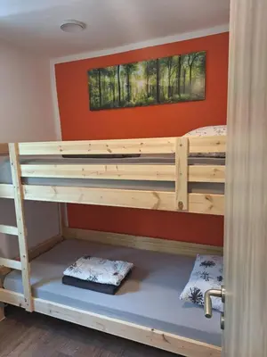 a bunk bed in a room with an orange wall at Tomas Old House - River Apartments in Visoko