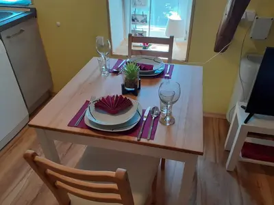 a wooden table with plates and wine glasses on it at Tomas Old House - River Apartments in Visoko