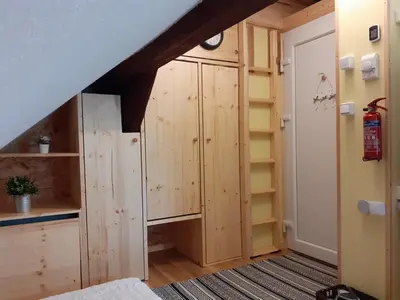 an attic room with wooden cabinets and a staircase at Tomas Old House - River Apartments in Visoko