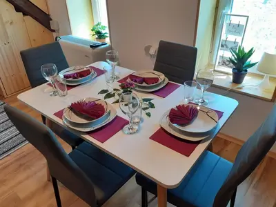 a dining room table with plates and glasses on it at Tomas Old House - River Apartments in Visoko