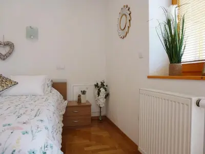 a bedroom with a bed and a plant on the wall at Apartment Jalps 1 in beautiful Bohinjska Bistrica in Bohinj