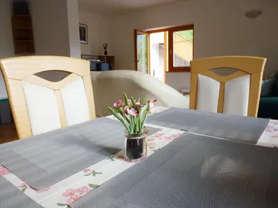 a dining room table with a vase of flowers on it at Apartment Jalps 1 in beautiful Bohinjska Bistrica in Bohinj