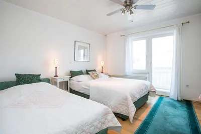 a white bedroom with two beds and a window at B&B Pletna a Double Lake-View Room in Bled