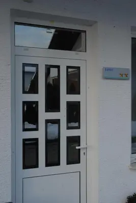 a white garage door with a sign on it at Guest Accomodation Škerlak in Moravske Toplice