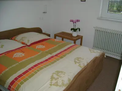 a bedroom with a bed and a table with flowers at Guest Accomodation Škerlak in Moravske Toplice