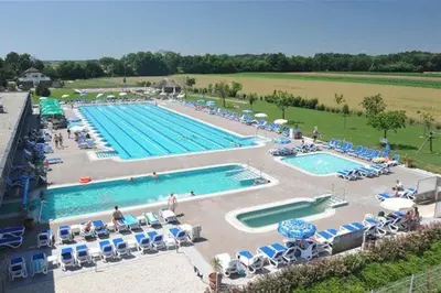 a large swimming pool with chairs and umbrellas at Guest Accomodation Škerlak in Moravske Toplice
